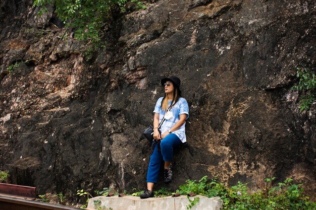 I viaggiatori asiatici le donne tailandesi viaggiano visitano e posano il ritratto sulla montagna della scogliera per scattare foto alla grotta di Tham krasae nel Parco nazionale delle cascate di Sai Yok alla grotta di Tham krasae a Kanchanaburi Thailandia