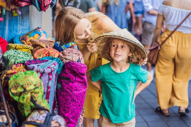 I viaggiatori di mamma e figlio scelgono souvenir nel mercato di Ubud a Bali, in Indonesia