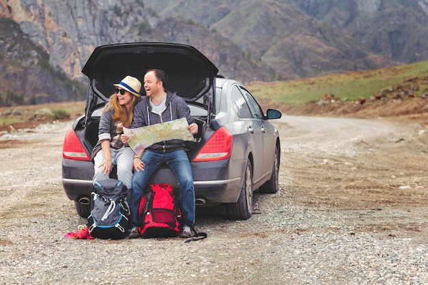 I viaggiatori in auto in montagna in primavera vedono la mappa