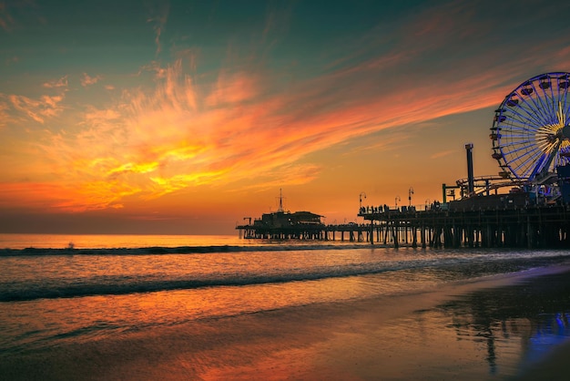 I visitatori si godono il tramonto sopra il molo di Santa Monica a Los Angeles