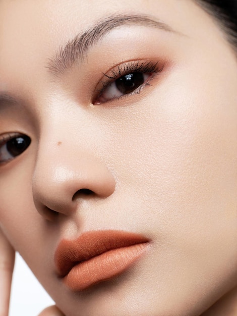I volti delle donne asiatiche sono abbelliti con volti cosmetici per la pubblicità