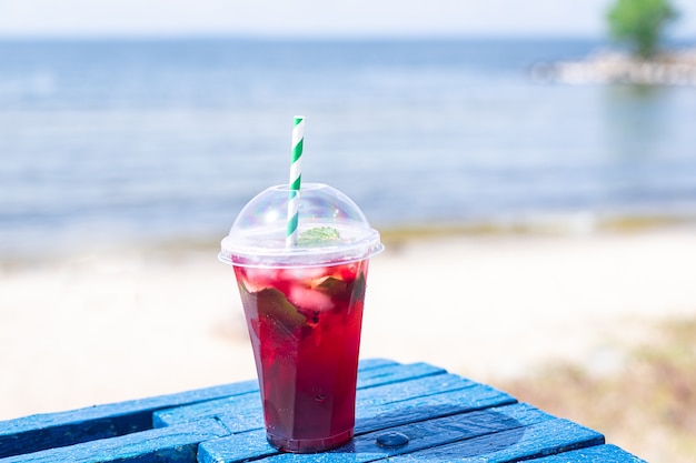 Ice drink rosso limonata soda sulla spiaggia ciliegia o succo di fragola fresco mare costa riva estate surf onda