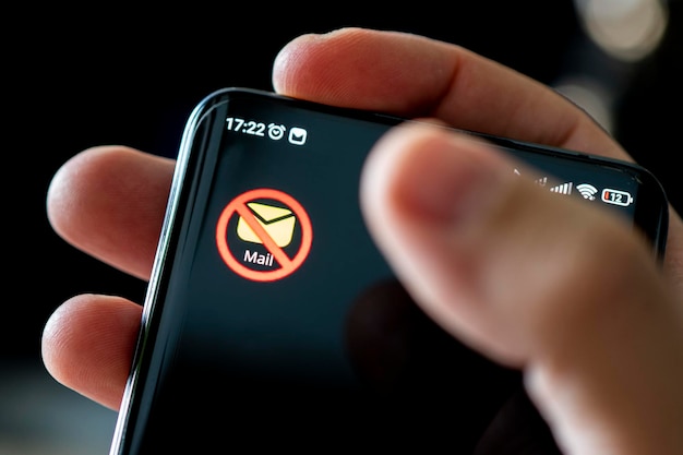 Icona dell'e-mail bloccata sullo schermo di uno smartphone nero Il concetto di vietare i servizi di posta elettronica