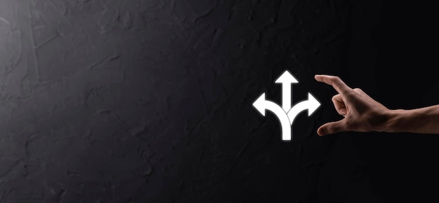 Icona della tenuta della mano maschile con l'icona a tre direzioni su sfondo scuro. Dubbio, dover scegliere tra tre diverse scelte indicate da frecce che puntano in senso opposto concept. Modi