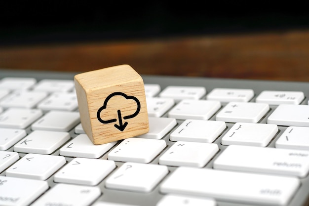 Icona di download di cloud computing sul cubo di legno su una tastiera di computer bianca
