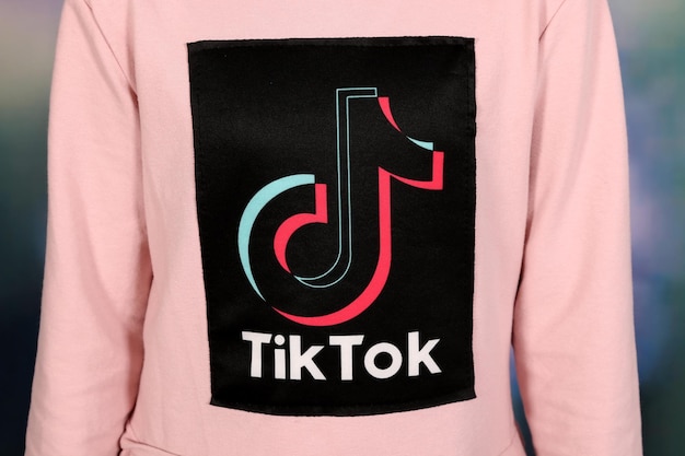 Icona di Tik Tok Logo dei social media sulla maglietta rosa della ragazza. Design del logo Tik Tok.