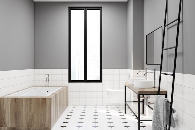 Ideazione moderna di decorazione del bagno grigio. Un pavimento piastrellato bianco e nero, una finestra stretta, una vasca di legno, un doppio lavandino e una scala.