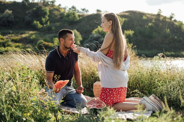 Idee per un picnic romantico per una giovane coppia innamorata durante un picnic estivo con l'anguria