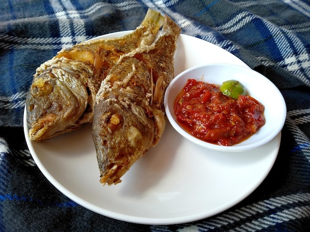 Ikan Goreng o pesce fritto con piccante su un piatto cibo culinario indonesiano