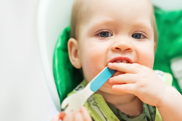 Il bambino a tavola è sporco di pasta alimentare Il bambino allatta il bambino mangia con il cucchiaio alimenta le feci problemi di stomaco nei neonati