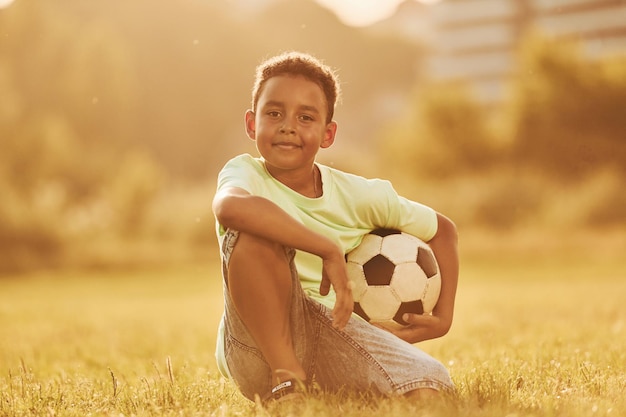 Il bambino afroamericano del bel sole si diverte sul campo durante il giorno d'estate