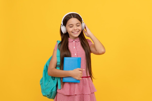 Il bambino allegro con la ragazza adolescente di musica della borsa della scuola porta lo zaino a scuola