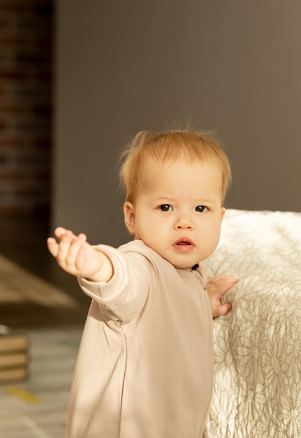 Il bambino asiatico si allunga e guarda nella telecamera appoggiato sul letto