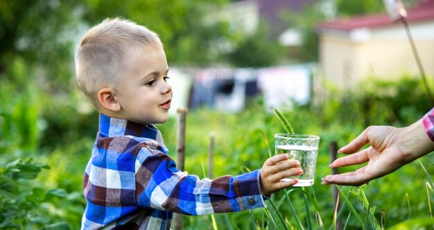 Il bambino beve acqua pulita in natura.