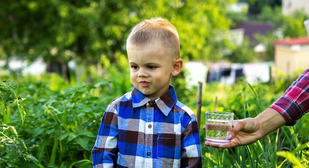 Il bambino beve acqua pulita in natura.