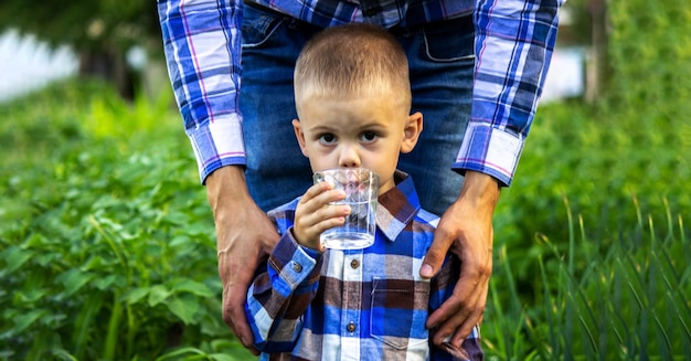 Il bambino beve acqua pulita in natura.