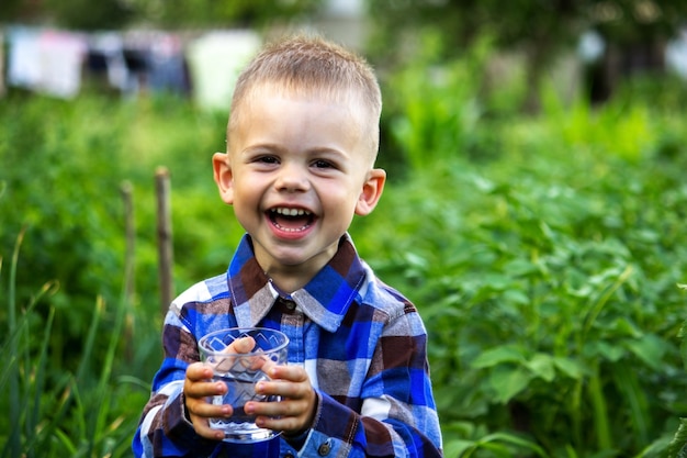 Il bambino beve acqua pulita in natura.