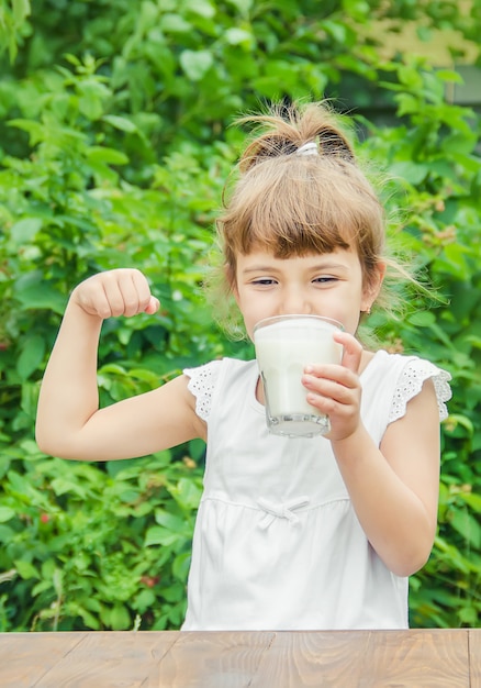 Il bambino beve latte e biscotti. Messa a fuoco selettiva