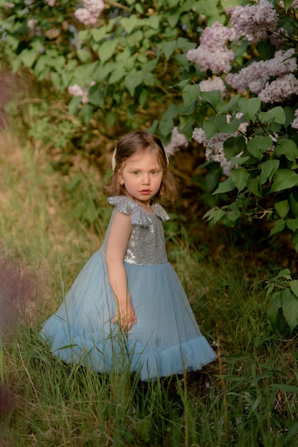 Il bambino cammina nel parco bambina vestita con un vestito blu