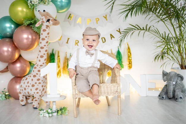 Il bambino carino festeggia il suo primo compleanno sullo sfondo di palloncini colorati luminosi e oggetti di scena festivi la prima vacanza per bambini