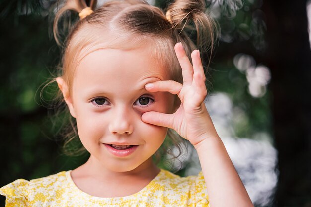 Il bambino caucasico di 6 anni è una bella ragazza con gli occhi spalancati, guarda la telecamera. Emozioni facciali espressive