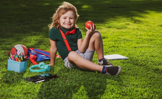 Il bambino che studia online all'aperto nel parco studia nelle classi scolastiche online della natura