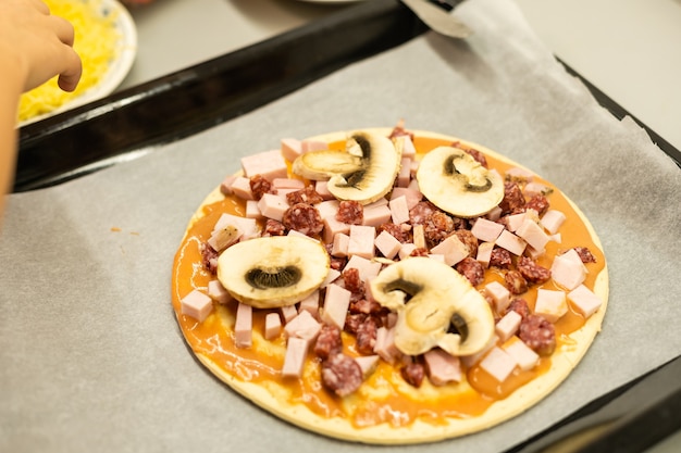 il bambino cucina la pizza fatta in casa, la bambina fa la pizza a casa