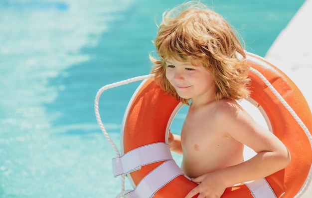 Il bambino della guardia di vita fa attenzione a salvare l'acqua aiutando il concetto di bambino con il cerchio di salvataggio