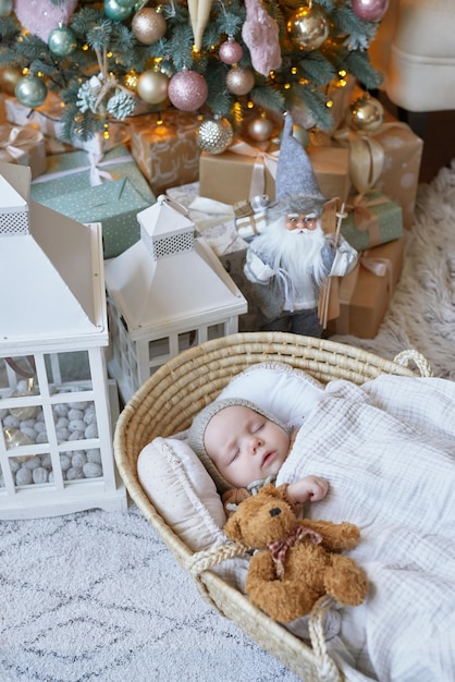 Il bambino di Babbo Natale dorme nella culla vicino all'albero di Natale Buon Natale e felice anno nuovo