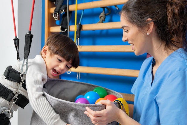 Il bambino disabile sta giocando imparando ed esercitandosi nello stile di vita ospedaliero di terapia riabilitativa di un ...