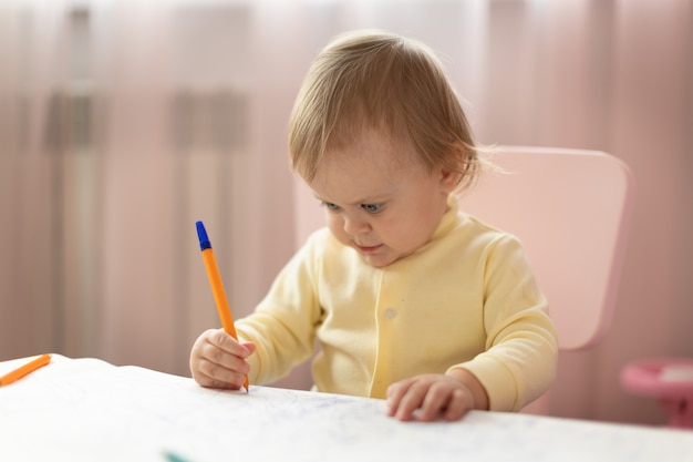 Il bambino disegna al tavolo in camera