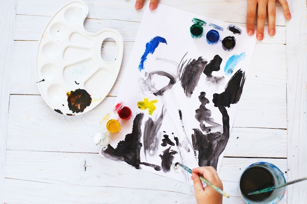 il bambino disegna un pennello e dipinge la vista dall'alto