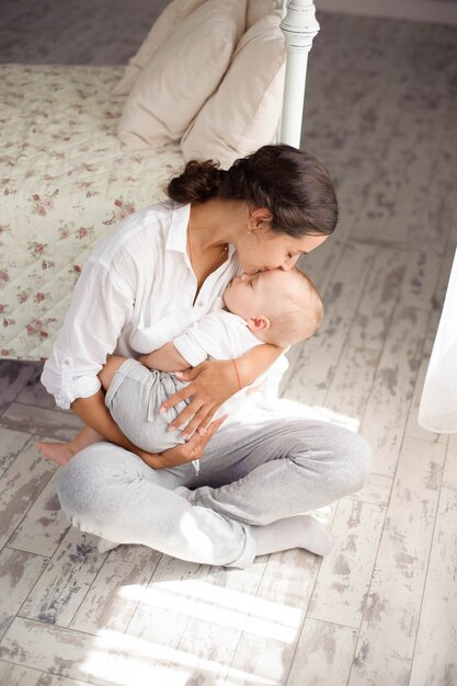 Il bambino dorme sul petto della madre. Giovane madre coccole bambino