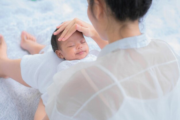 Il bambino dorme sulla madre della mamma che trasporta e tocca il suo bambino con tenerezza e tenerezza