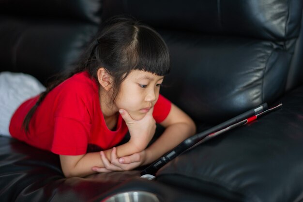 Il bambino è dipendente dal tablet bambina che gioca su smartphone bambino usa il telefono guardando il cartone animato