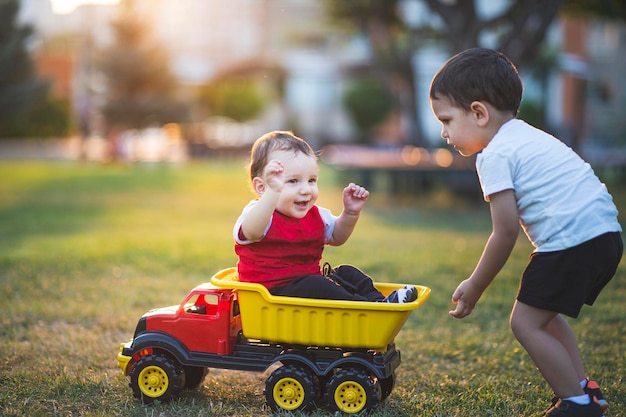 Il bambino e il fratellino si divertono insieme il fratello maggiore sta spingendo il camion per rendere felice suo fratello