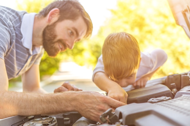 Il bambino e il padre che riparano una macchina