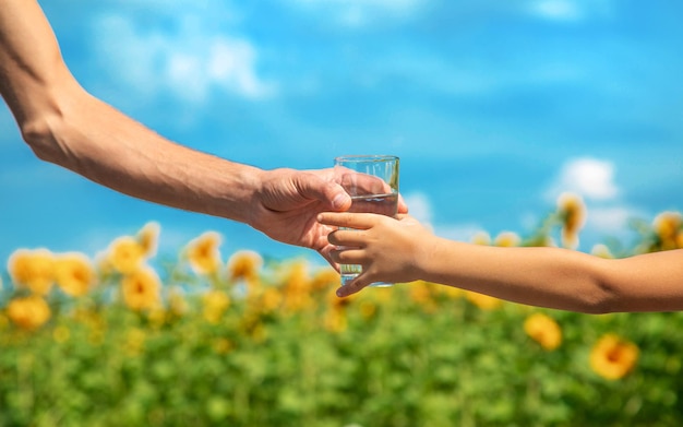 Il bambino e il padre tengono in mano un bicchiere d'acqua. Messa a fuoco selettiva.