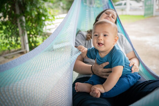 Il bambino e la madre sono seduti sull&#39;amaca, entrambi sono felici