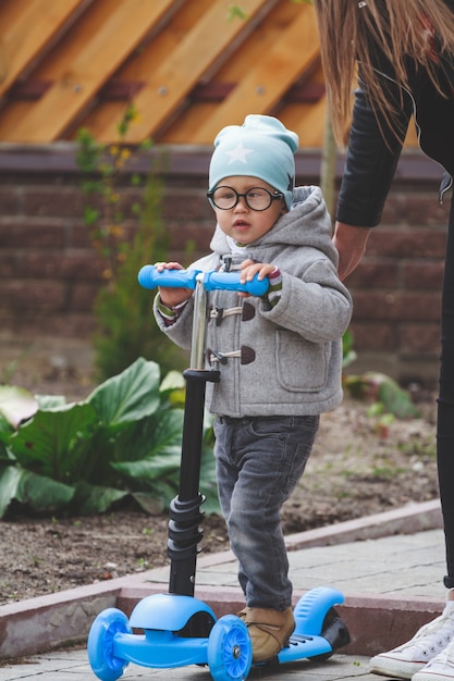 Il bambino e la mamma giocano all'aperto con gli scooter.