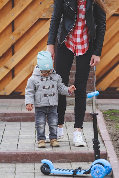 Il bambino e la mamma giocano all'aperto con gli scooter.