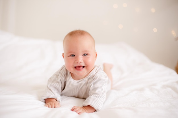 Il bambino è sdraiato a casa sul letto sorridente