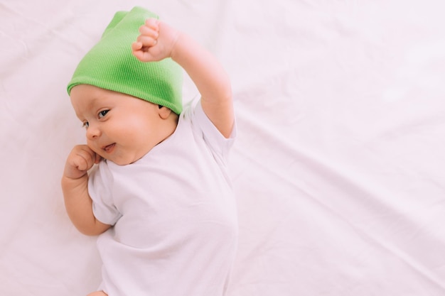 Il bambino è sdraiato nella sua culla e guardando la telecamera Un bambino felice Articolo per bambini