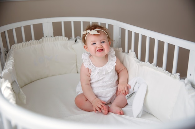 il bambino è seduto nella culla in camera da letto sorridendo