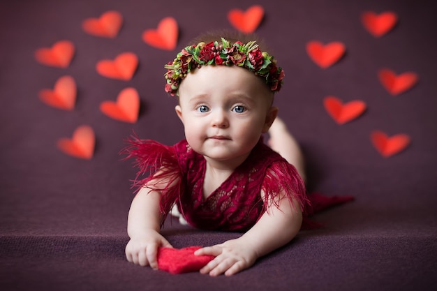 Il bambino è una ragazza su uno sfondo bordeaux con cuori San Valentino San Valentino