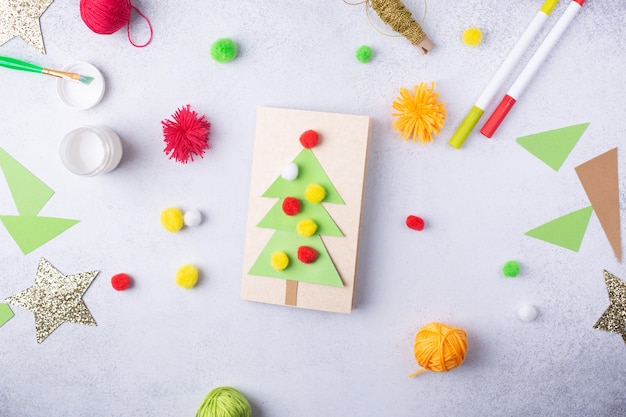 Il bambino fa un biglietto di auguri Natale collage di carta bambini progetto artistico mestiere per bambini foto di alta qualità