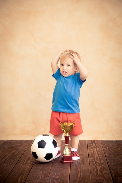 Il bambino finge di essere un giocatore di calcio Concetto di successo e vincitore