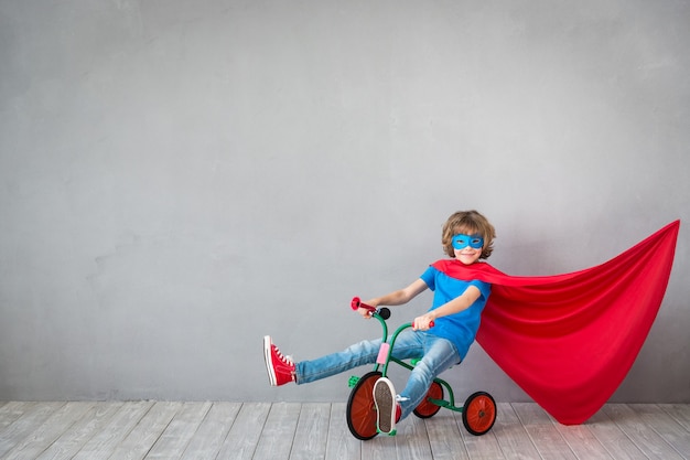 Il bambino finge di essere un supereroe. Bambino che gioca in casa. Concetto di successo, creatività e immaginazione