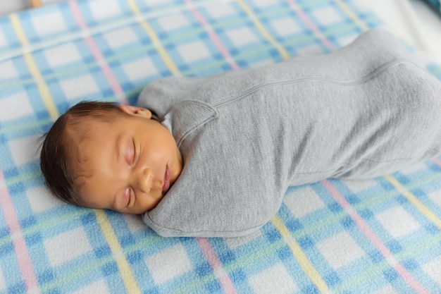 Il bambino giace in un bozzolo sul lettino Dorme dolcemente e sogna