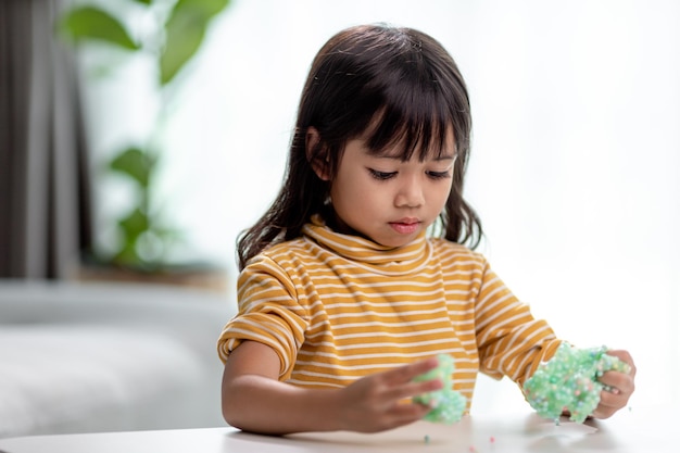 Il bambino gioca con la gomma Slime nelle mani dei bambini